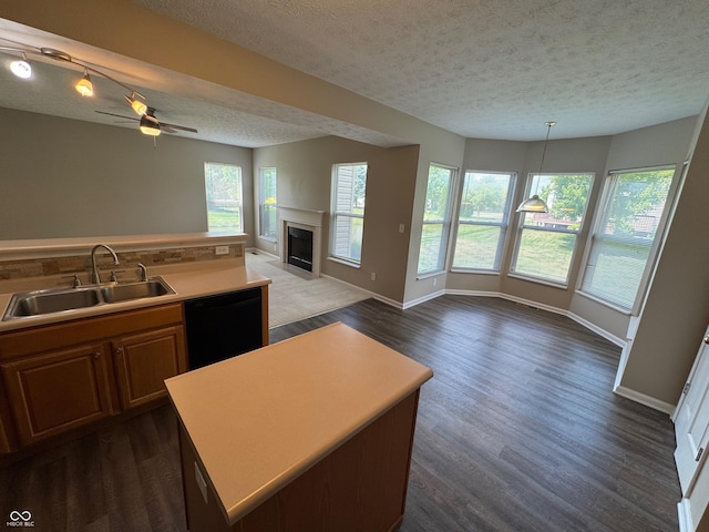 14520 Brackney Ln, Carmel, IN 46032 - kitchen featuring a textured ceiling, black dishwasher, ceiling fan, a fireplace with flush hearth, and open floor plan