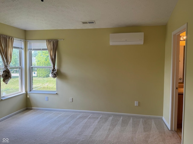 14520 Brackney Ln, Carmel, IN 46032 - spare room with a wall unit AC, light carpet, and a textured ceiling