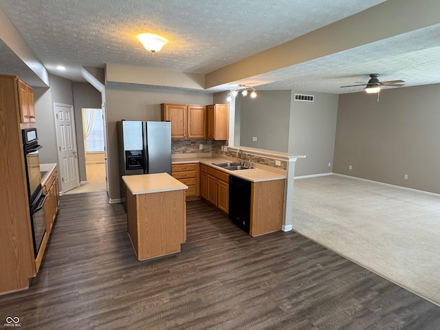 14520 Brackney Ln, Carmel, IN 46032 - kitchen with black appliances, a textured ceiling, a peninsula, light countertops, and a kitchen island