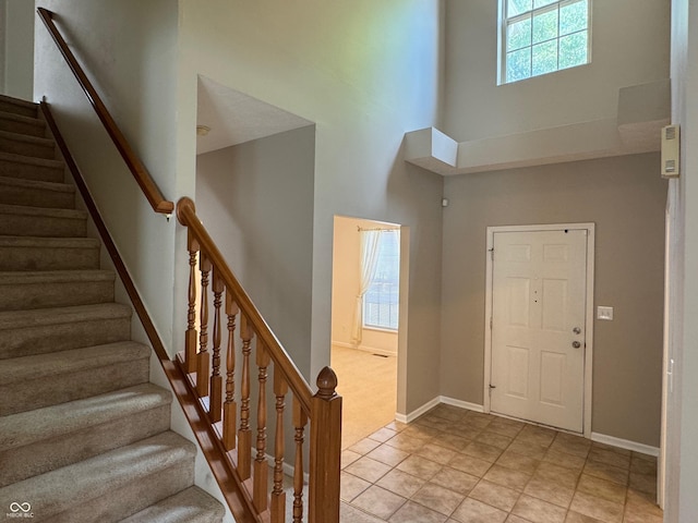 14520 Brackney Ln, Carmel, IN 46032 - foyer featuring a towering ceiling, light tile patterned flooring, stairway, and light carpet