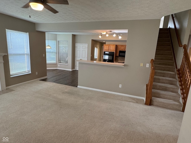 14520 Brackney Ln, Carmel, IN 46032 - unfurnished living room featuring ceiling fan, dark colored carpet, stairway, a textured ceiling, and a fireplace with flush hearth