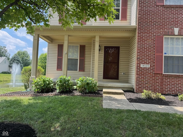 14520 Brackney Ln, Carmel, IN 46032 - doorway to property featuring a yard, brick siding, and covered porch