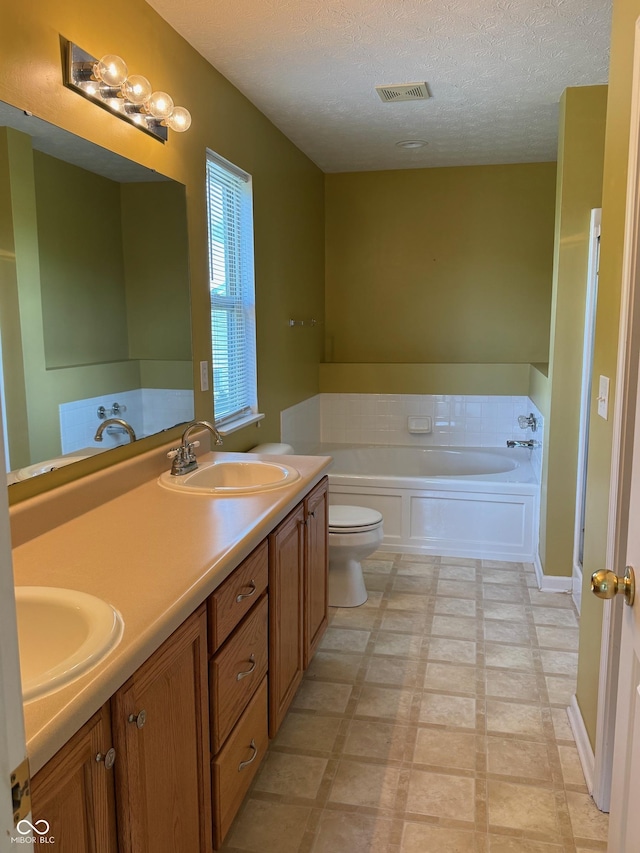 14520 Brackney Ln, Carmel, IN 46032 - bathroom featuring a bath, double vanity, a textured ceiling, and tile patterned floors