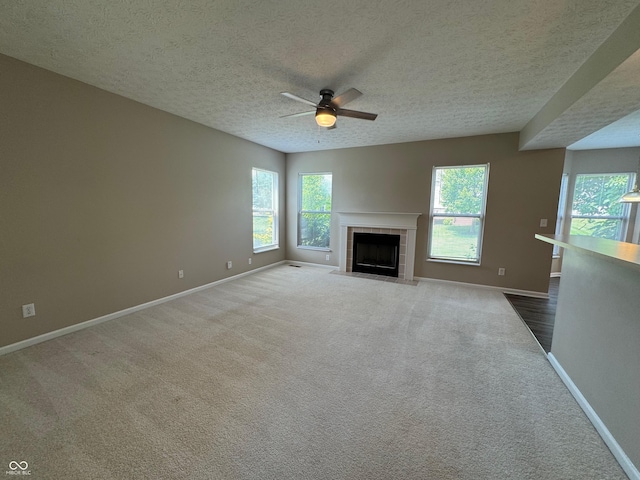 14520 Brackney Ln, Carmel, IN 46032 - unfurnished living room with a textured ceiling, a ceiling fan, carpet floors, and a tiled fireplace
