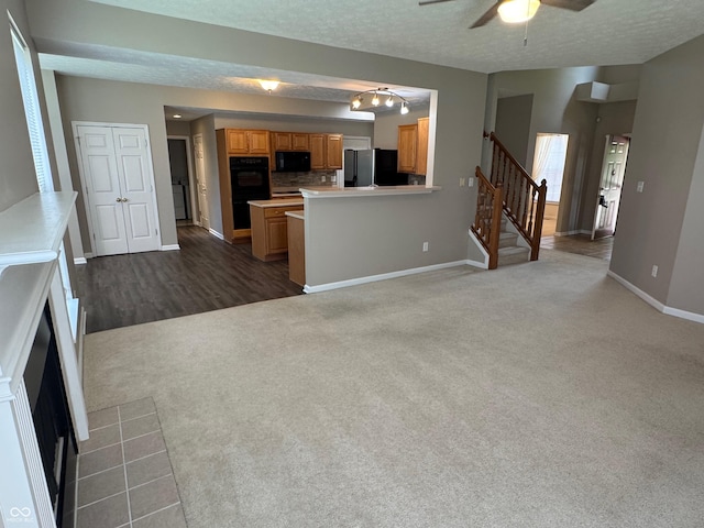 14520 Brackney Ln, Carmel, IN 46032 - unfurnished living room featuring dark colored carpet, ceiling fan, a fireplace, a textured ceiling, and stairway