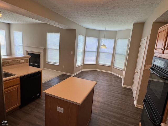 14520 Brackney Ln, Carmel, IN 46032 - kitchen with black appliances, a textured ceiling, open floor plan, a fireplace, and dark wood-style flooring