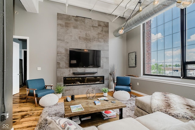624 E Walnut St Unit 26, Indianapolis, IN 46204 - living area with wood finished floors, a tiled fireplace, and a high ceiling
