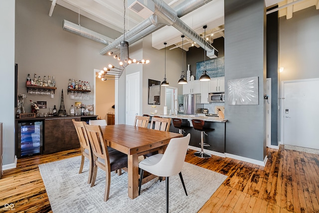 624 E Walnut St Unit 26, Indianapolis, IN 46204 - dining room featuring a high ceiling, beverage cooler, hardwood / wood-style flooring, and bar area