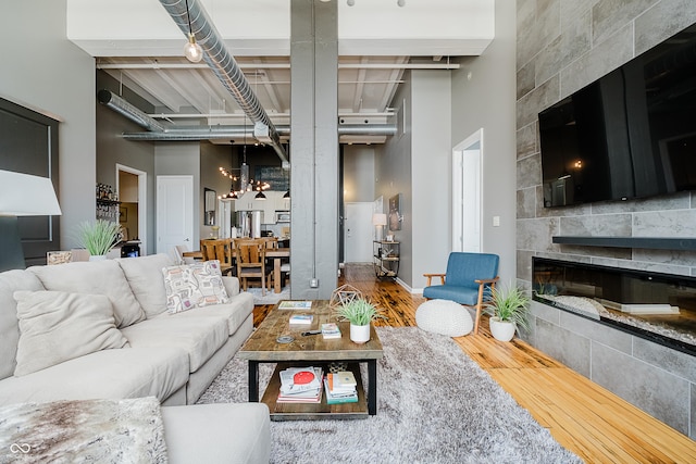 624 E Walnut St Unit 26, Indianapolis, IN 46204 - living room with a chandelier, wood finished floors, a towering ceiling, and a tiled fireplace