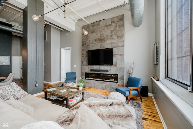 624 E Walnut St Unit 26, Indianapolis, IN 46204 - living room with wood finished floors, a tile fireplace, and a towering ceiling