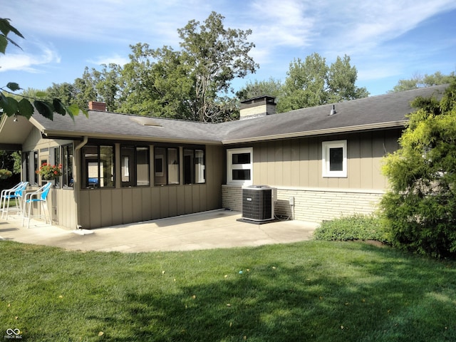 4008 Washington St, Columbus, IN 47203 - rear view of house featuring a chimney, a patio area, a yard, and roof with shingles