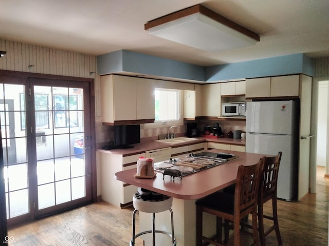 4008 Washington St, Columbus, IN 47203 - kitchen with white appliances, tasteful backsplash, light wood finished floors, and a breakfast bar