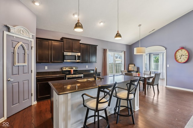 897 Sommersweet Run, Greenwood, IN 46143 - kitchen featuring appliances with stainless steel finishes, vaulted ceiling, dark brown cabinets, dark wood-style flooring, and a breakfast bar