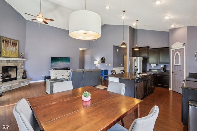 897 Sommersweet Run, Greenwood, IN 46143 - dining area with high vaulted ceiling, a ceiling fan, dark wood-style flooring, and a stone fireplace