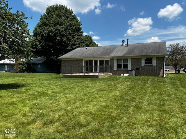 321 S Locust Dr, Morristown, IN 46161 - rear view of house featuring a yard, brick siding, and a sunroom