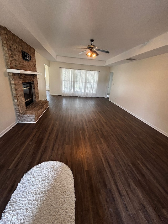 321 S Locust Dr, Morristown, IN 46161 - unfurnished living room with wood finished floors, ceiling fan, and a brick fireplace