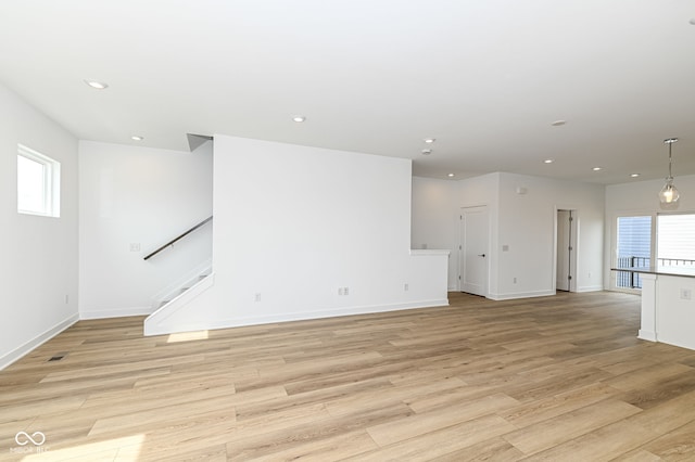 2416 Winthrop Ave, Indianapolis, IN 46205 - unfurnished living room featuring plenty of natural light, light wood-style floors, recessed lighting, and stairs