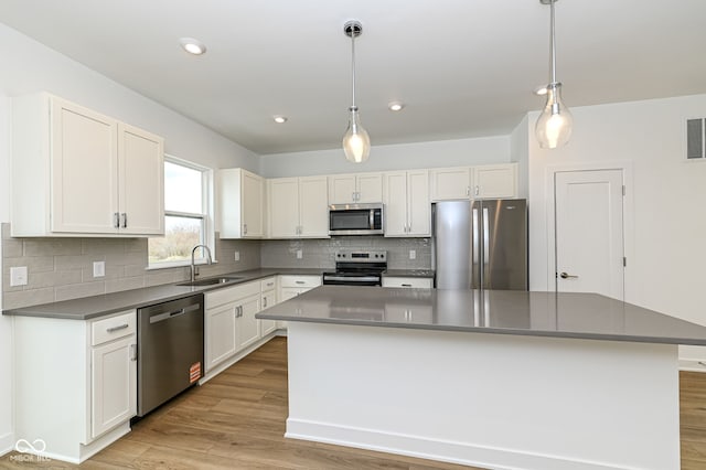 2416 Winthrop Ave, Indianapolis, IN 46205 - kitchen with stainless steel appliances, light wood-style flooring, a kitchen island, tasteful backsplash, and recessed lighting