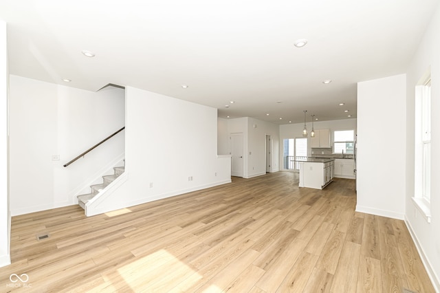 2416 Winthrop Ave, Indianapolis, IN 46205 - unfurnished living room featuring light wood-type flooring, recessed lighting, and stairway