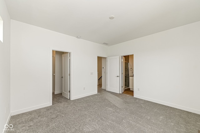 2416 Winthrop Ave, Indianapolis, IN 46205 - unfurnished bedroom with carpet floors, a walk in closet, and connected bathroom
