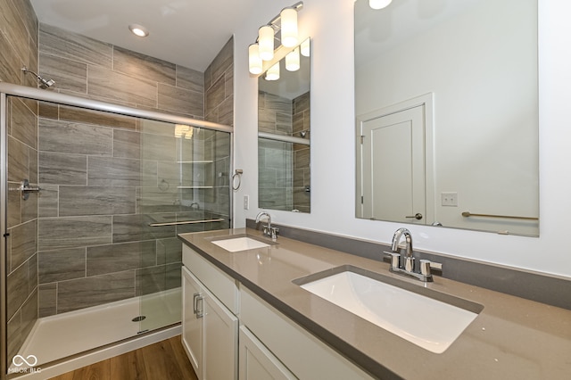 2416 Winthrop Ave, Indianapolis, IN 46205 - full bathroom with double vanity, a stall shower, recessed lighting, and wood finished floors