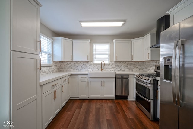 1409 Terrace Ave, Indianapolis, IN 46203 - kitchen with appliances with stainless steel finishes, wall chimney exhaust hood, healthy amount of natural light, and white cabinetry