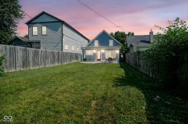 1409 Terrace Ave, Indianapolis, IN 46203 - back of property at dusk with a fenced backyard and a patio area