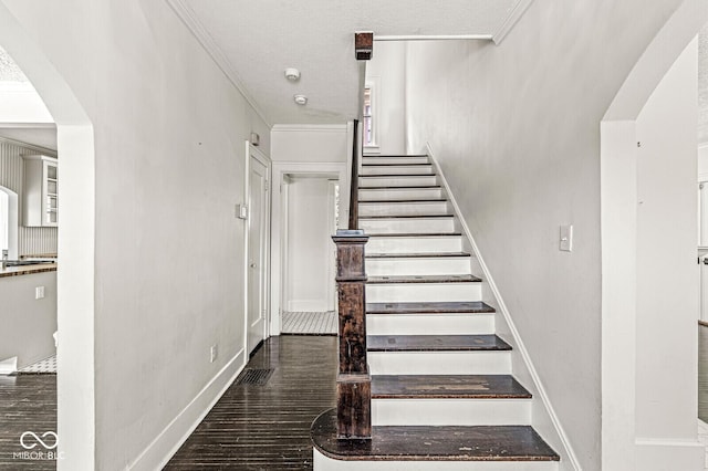 4123 N Illinois St, Indianapolis, IN 46208 - staircase featuring wood finished floors, arched walkways, and crown molding