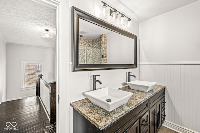 4123 N Illinois St, Indianapolis, IN 46208 - full bath with double vanity, wood finished floors, a textured ceiling, and a wainscoted wall