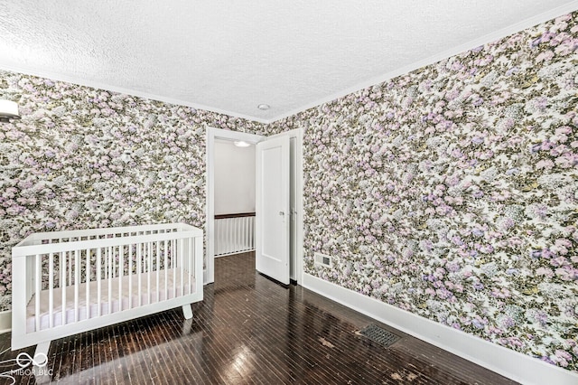 4123 N Illinois St, Indianapolis, IN 46208 - unfurnished bedroom with wallpapered walls, ornamental molding, a textured ceiling, and wood finished floors