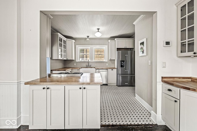 4123 N Illinois St, Indianapolis, IN 46208 - kitchen with stainless steel appliances, butcher block countertops, light floors, a peninsula, and glass insert cabinets