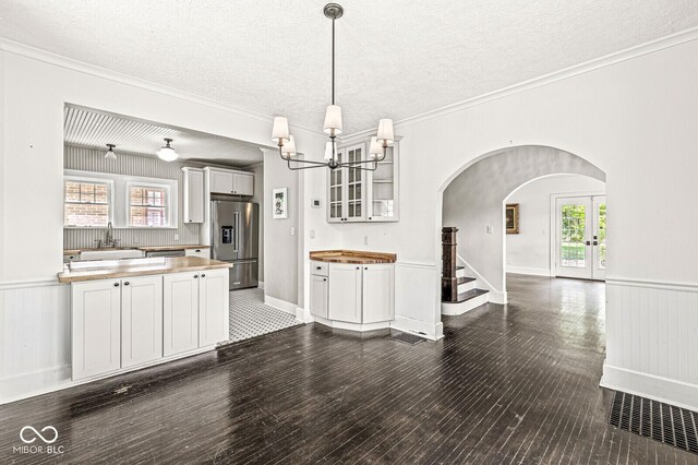 4123 N Illinois St, Indianapolis, IN 46208 - kitchen featuring high quality fridge, arched walkways, glass insert cabinets, dark wood finished floors, and a chandelier