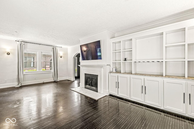 4123 N Illinois St, Indianapolis, IN 46208 - unfurnished living room with a textured ceiling, a glass covered fireplace, arched walkways, dark wood-style floors, and crown molding