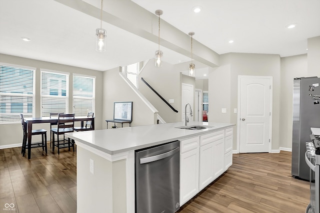 887 Tuxedo Dr, Westfield, IN 46074 - kitchen featuring appliances with stainless steel finishes, wood finished floors, light countertops, white cabinets, and decorative light fixtures