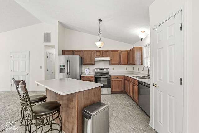 3772 Brill Rd, Indianapolis, IN 46227 - kitchen with stainless steel appliances, vaulted ceiling, under cabinet range hood, light countertops, and a breakfast bar