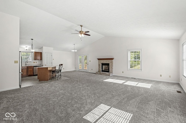 3772 Brill Rd, Indianapolis, IN 46227 - unfurnished living room with ceiling fan, carpet, a brick fireplace, a chandelier, and high vaulted ceiling