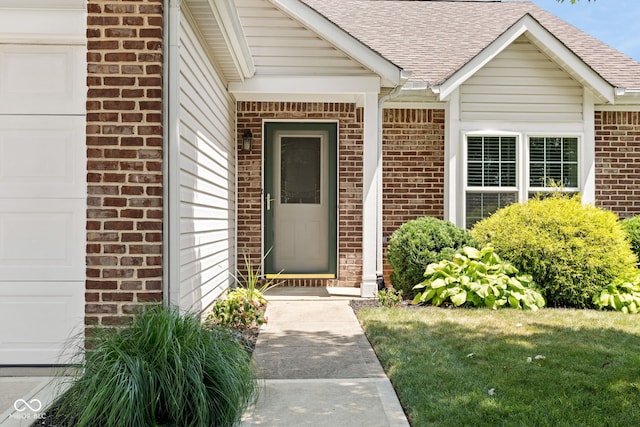 12384 Barnstone Ct, Fishers, IN 46037 - view of exterior entry with brick siding, roof with shingles, and a garage