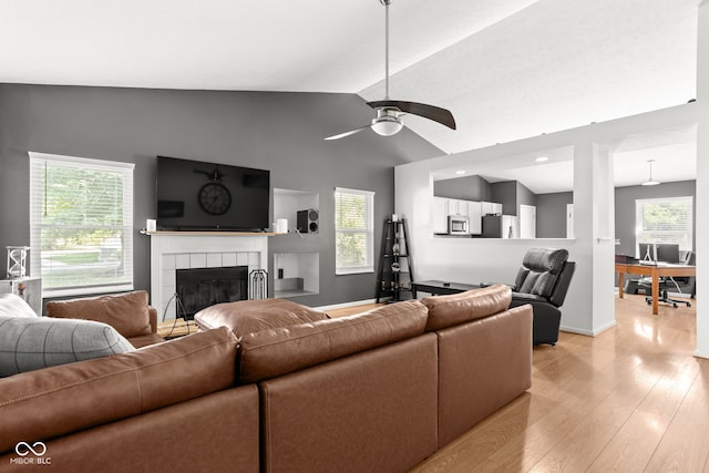 12384 Barnstone Ct, Fishers, IN 46037 - living room featuring vaulted ceiling, a tile fireplace, light wood-type flooring, and ceiling fan