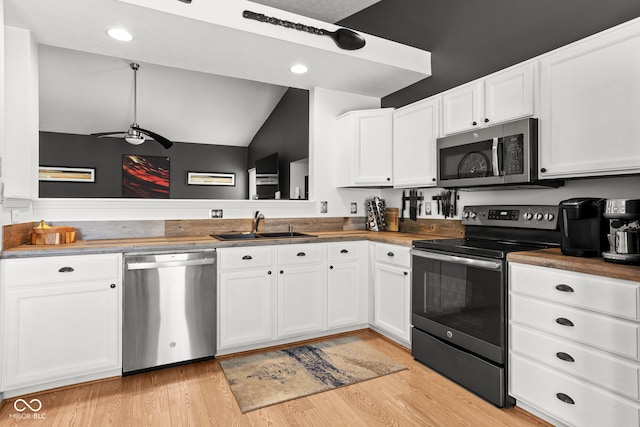 12384 Barnstone Ct, Fishers, IN 46037 - kitchen with stainless steel appliances, white cabinetry, ceiling fan, light wood finished floors, and lofted ceiling