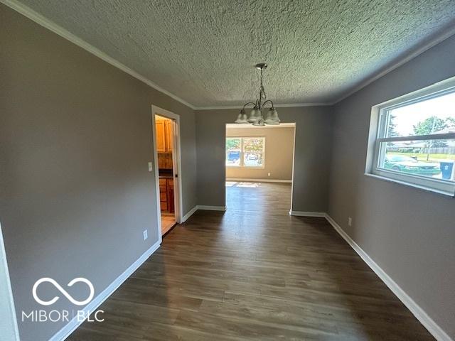 2732 Morning Star Dr, Indianapolis, IN 46229 - unfurnished dining area featuring a chandelier, a textured ceiling, crown molding, and dark wood-style floors