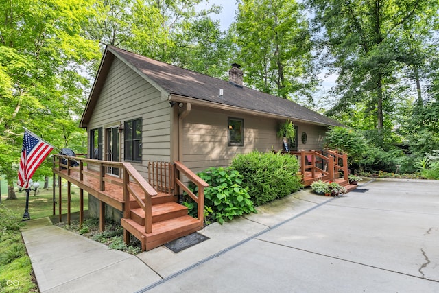 2591 S Glen Cv, Martinsville, IN 46151 - view of front of property featuring a wooden deck, a chimney, a patio, and a shingled roof