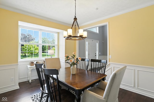 682 Shannon Ct, Noblesville, IN 46062 - dining area featuring a chandelier, dark wood-style flooring, a wainscoted wall, crown molding, and a decorative wall