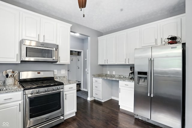 682 Shannon Ct, Noblesville, IN 46062 - kitchen with appliances with stainless steel finishes, dark wood-type flooring, white cabinetry, light stone countertops, and a textured ceiling