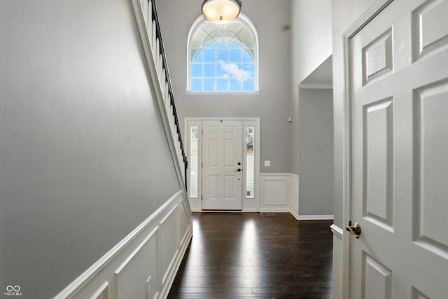 682 Shannon Ct, Noblesville, IN 46062 - entrance foyer with wainscoting, dark wood-style floors, a decorative wall, a towering ceiling, and stairway