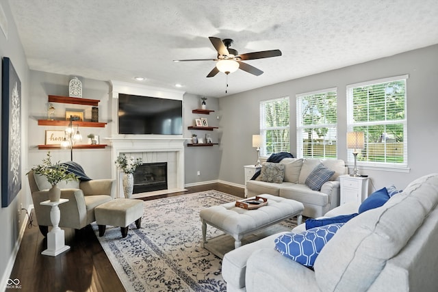 682 Shannon Ct, Noblesville, IN 46062 - living room with wood finished floors, a ceiling fan, a tiled fireplace, a textured ceiling, and recessed lighting