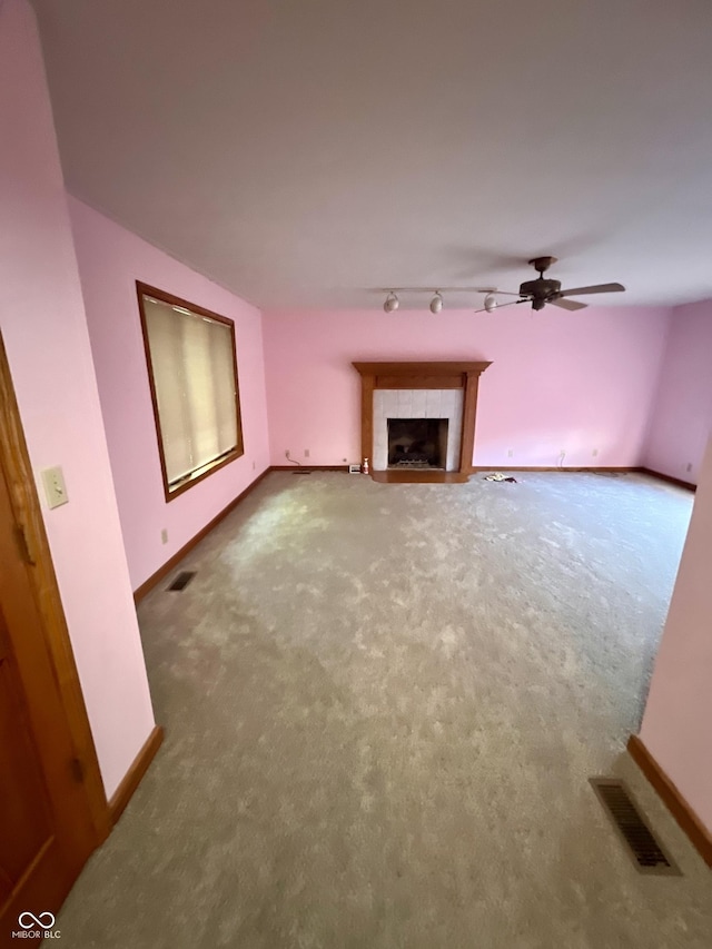 7057 Bluffwood Ct, Brownsburg, IN 46112 - unfurnished living room with carpet, rail lighting, a ceiling fan, and a fireplace