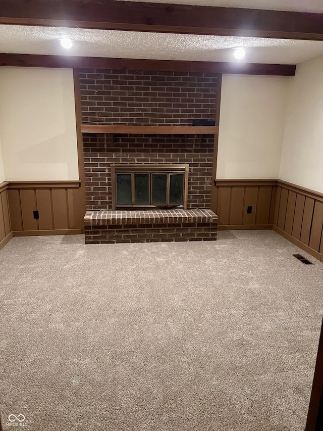 7057 Bluffwood Ct, Brownsburg, IN 46112 - unfurnished living room with wainscoting, a fireplace, carpet floors, a textured ceiling, and a decorative wall