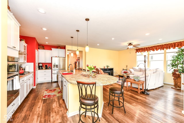 5119 Silverbell Dr, Plainfield, IN 46168 - kitchen with appliances with stainless steel finishes, dark wood-style flooring, a breakfast bar area, recessed lighting, and a spacious island