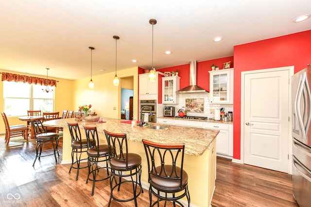 5119 Silverbell Dr, Plainfield, IN 46168 - kitchen featuring wall chimney range hood, stainless steel appliances, a kitchen breakfast bar, dark wood finished floors, and white cabinets