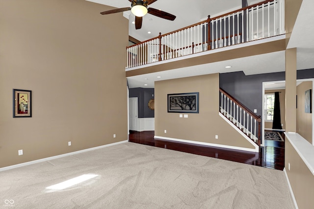 10267 Ranford Blvd, Fishers, IN 46040 - unfurnished living room featuring carpet flooring, a ceiling fan, a high ceiling, stairs, and recessed lighting